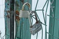 Two gray padlock on an iron green gate