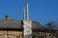 Two gray pipes on a brick chimney on a gray slate roof of a rural house Royalty Free Stock Photo