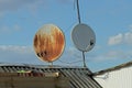 Two gray round satellite dishes in brown rust on the slate roof Royalty Free Stock Photo