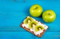 Two green apple and healthy grain sandwich with cream cheese and kiwi slices. A useful homemade breakfast. Vegetarian food. Royalty Free Stock Photo