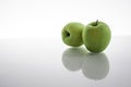 Two green apples isolated on white background with reflex on glass