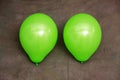 Two green balloons against brown wallpaper Royalty Free Stock Photo