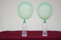 Two green balloons on top of bottles. Royalty Free Stock Photo