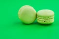 Two green cake macaron on green background, maccarone sweet dessert