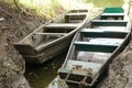 Two green canoes lying in river on the waterfront