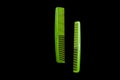 Two green combs on a black background, isolate Royalty Free Stock Photo