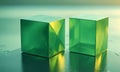 Two green cubes with reflective surfaces stand on reflective surface, casting shadow and reflecting the light. Royalty Free Stock Photo