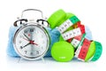 Two green dumbells, tape measure and alarm clock. Fitness and he