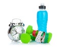 Two green dumbells, tape measure, drink bottle and alarm clock