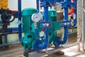 Two green electric pump on a water pipeline painted in blue. Industrial background. Royalty Free Stock Photo