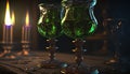 two green glass goblets sitting on a table next to a lit candle and some candlesticks in the dark ro Royalty Free Stock Photo