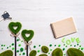 Two green grassy hearts, notebook and watering can on a white wooden background Royalty Free Stock Photo