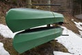 Two green kayaks stored in racks upside down in side view.