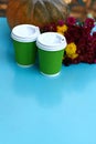 Two green paper disposable cups with coffee or tea on a blue table Royalty Free Stock Photo