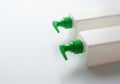 Two green pump dispensers on a white rectangular object isolated on white background Royalty Free Stock Photo