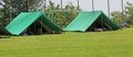 Two green tents mounted in a meadow by the scouts