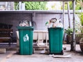 Two green trash cans overflowing