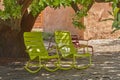 Two green vintage courtyard rocking chairs under a shady tree in a secluded and private garden at home. Patio furniture Royalty Free Stock Photo