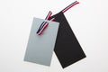 grey and black tag label with tricolor ribbon blue white red isolated in gray background Royalty Free Stock Photo