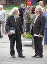 Two grey-headed elderly men speak