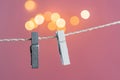 Two grey and white clothes pins on a clothes line rope holding nothing on a pink background Royalty Free Stock Photo