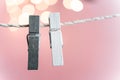 Two grey and white clothes pins on a clothes line rope holding nothing on a pink background Royalty Free Stock Photo