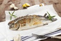 Two grilled trouts on wooden table.