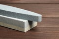 Two grindstones. Oval and rectangular double layer sharpening stone. Whetstone sharpener on wooden table Royalty Free Stock Photo
