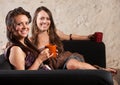 Two Grinning Ladies Sitting on Sofa Royalty Free Stock Photo
