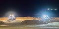 Two ground workers working at night in bulldozers at the beach moving the sand Royalty Free Stock Photo