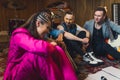 two guitarists, a drummer and a singer on the floor discussing about their new song in the studio Royalty Free Stock Photo