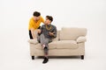 Two guys communicates sitting on the sofa. Portrait of three young friends spend time together sitting on the small sofa Royalty Free Stock Photo