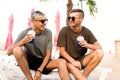 Two guys drink cocktails on a tropical beach Royalty Free Stock Photo