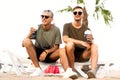 Two guys drink cocktails on a tropical beach Royalty Free Stock Photo
