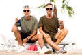 Two guys drink cocktails on a tropical beach Royalty Free Stock Photo