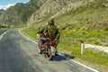 Two guys without helmets ride on an old Soviet red motorcycle on