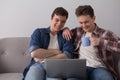Two guys with laptop on sofa. Royalty Free Stock Photo