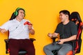 Two guys laugh and play video games with game controllers Royalty Free Stock Photo