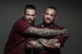 Two guys in red shirts with beards and tattoos. Royalty Free Stock Photo