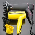 Two hair dryers with accessory on the grey mirror background Royalty Free Stock Photo