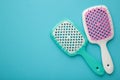 Two hairbrushes on blue background. Flat lay. Space for text Royalty Free Stock Photo