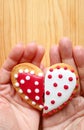 Two half heart shaped cookies in man`s hand and woman`s hand joining Royalty Free Stock Photo