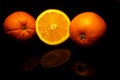 Two and a half orange isolated on black with reflections Royalty Free Stock Photo