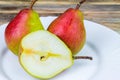 Two and half pears in white plate, rustic wooden table Royalty Free Stock Photo