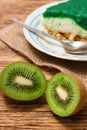 Two halfs of Kiwi fruit in front of green cake