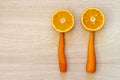 Two halfs of an orange and two carrots on wooden textured backgr Royalty Free Stock Photo