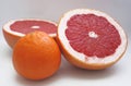 Two halfs of red grape fruit and an orange