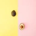 Two halves of avocado on a pastel yellow and pink background