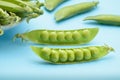 Two halves of a cracked pod of fresh peas on a blue background Royalty Free Stock Photo