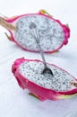 Two halves of dragon fruit with spoon on white background, tropical fruit Royalty Free Stock Photo